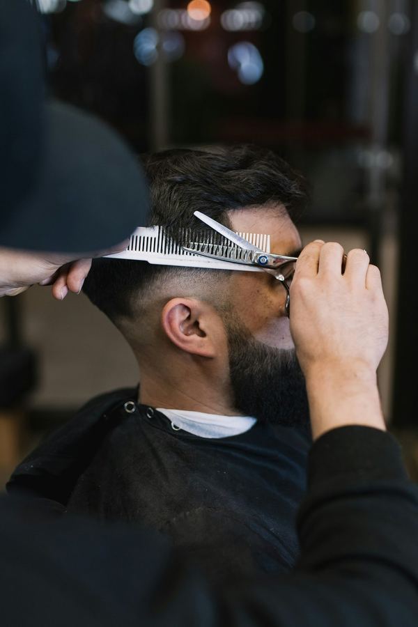 Scissors and comb working through the top of a haircut