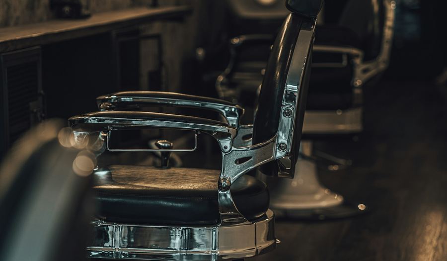 Two chrome barber's chairs standing in a row down the shop floor
