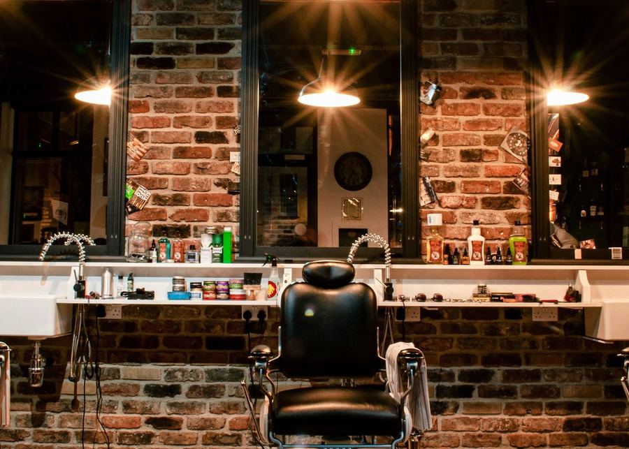 The counter along the brick wall with the pendant lamps burning above it